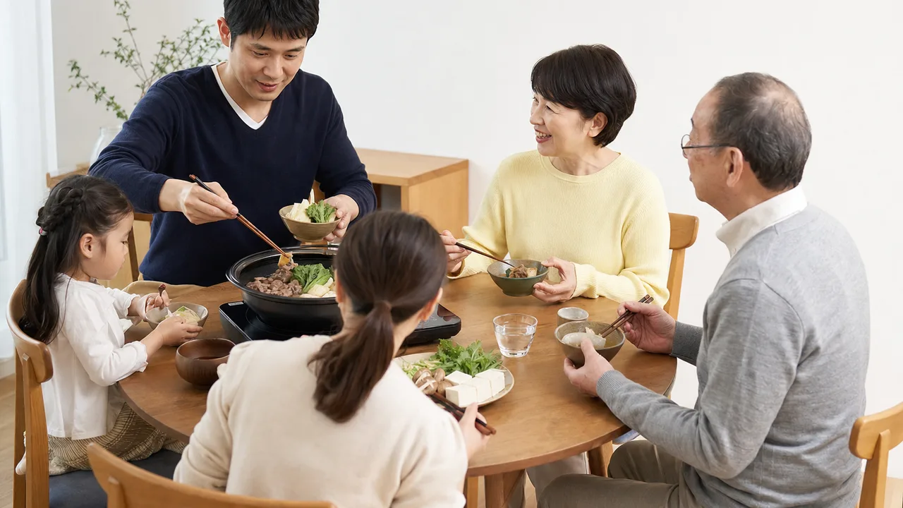 すき焼きを囲む日本人家族（横長・コピースペース）。すき焼き、家族、鍋料理、日本の食文化の記事向け素材です。