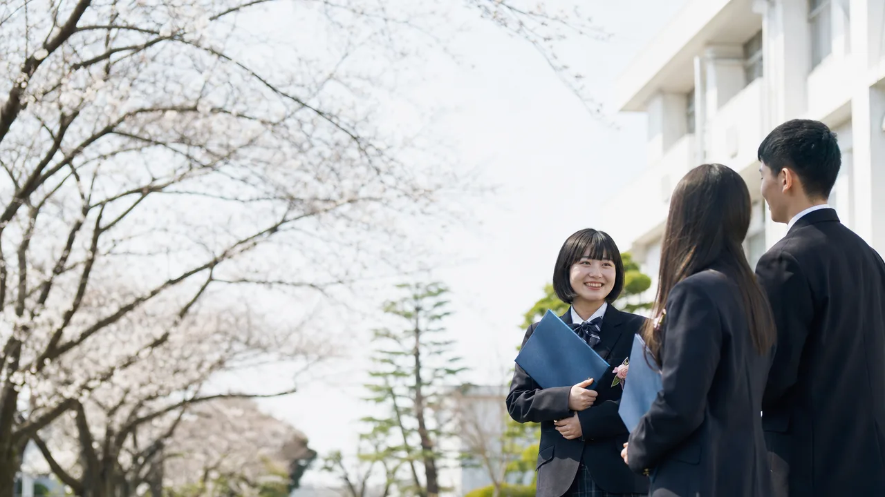 卒業式を終えた日本人学生（横長・コピースペース）。卒業、進路、学校、採用広報に使える、式後の学生たちの自然な素材です。