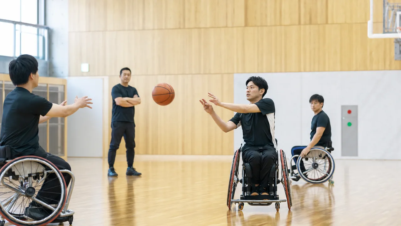 車いすバスケットボールを練習する日本人（横長・コピースペース）。車いすバスケットボール、パラスポーツ、車椅子、スポーツの記事や案内に使える商用素材です。