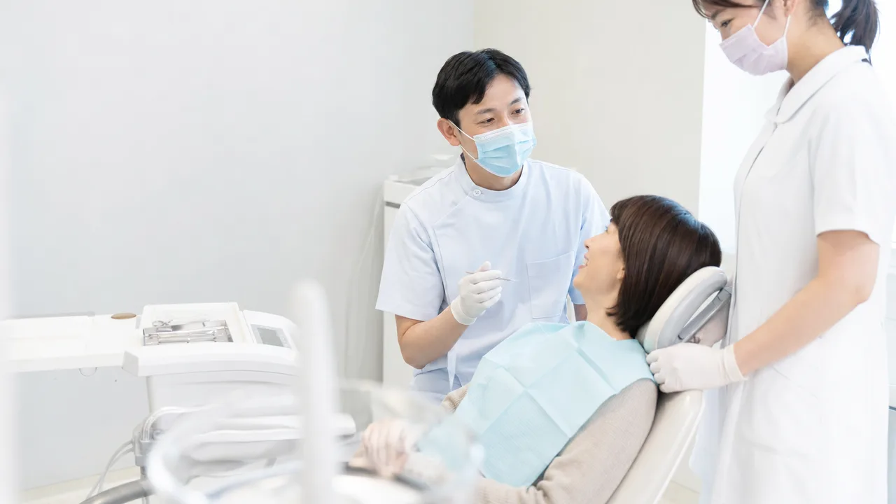 歯科健診を受ける日本人患者（横長・コピースペース）。歯医者、予防歯科、定期健診、口腔ケアの記事向け医療素材です。