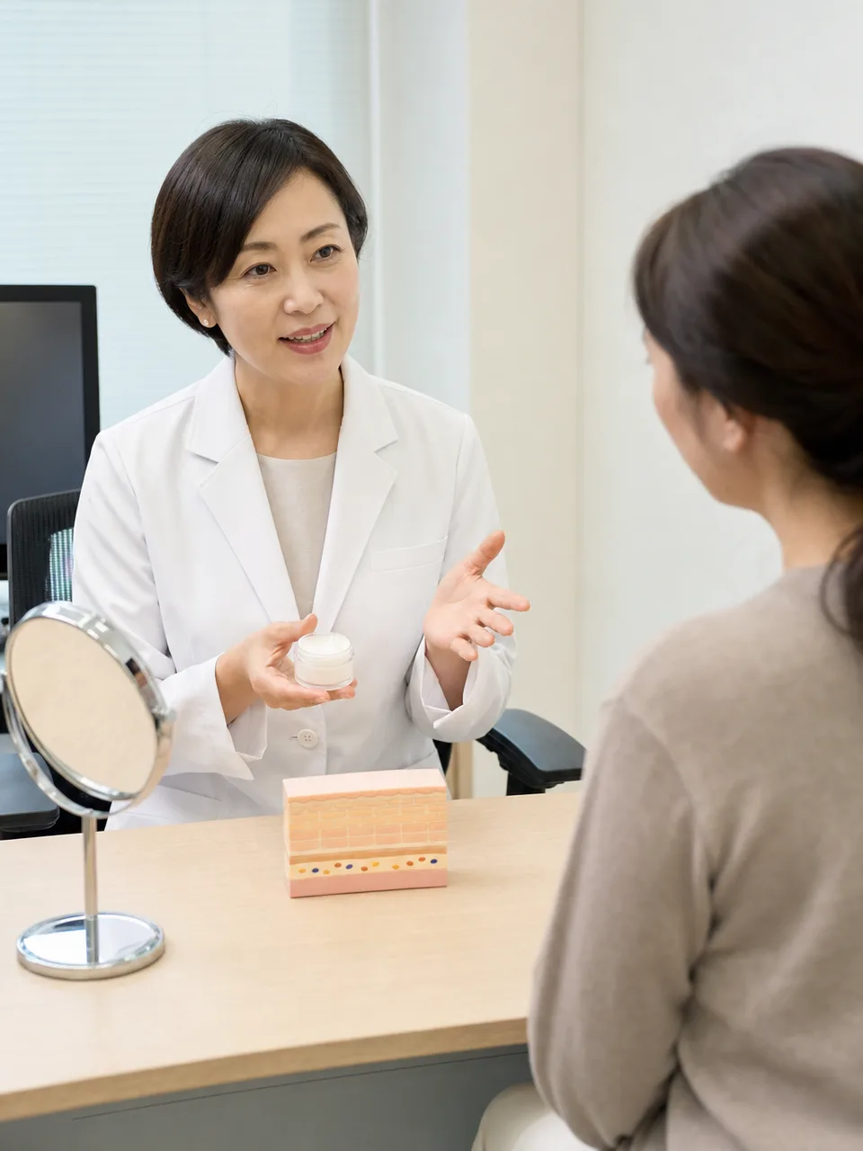 皮膚の健康を相談する日本人（自然な縦位置写真）。皮膚科相談、スキンケア、皮膚の健康、乾燥肌の記事や案内に使える商用素材です。