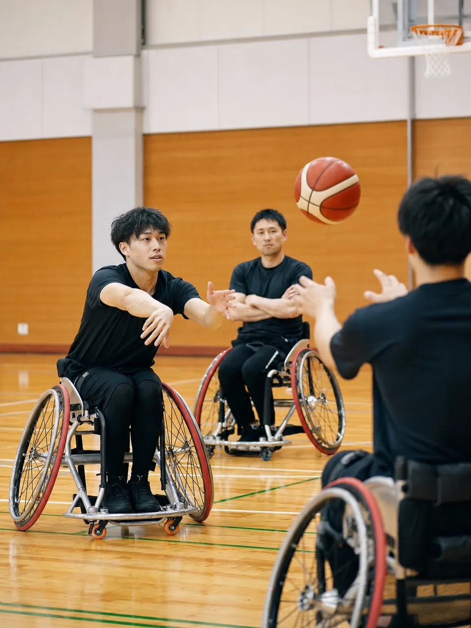 車いすバスケットボールを練習する日本人（自然な縦位置写真）。車いすバスケットボール、パラスポーツ、車椅子、スポーツの記事や案内に使える商用素材です。