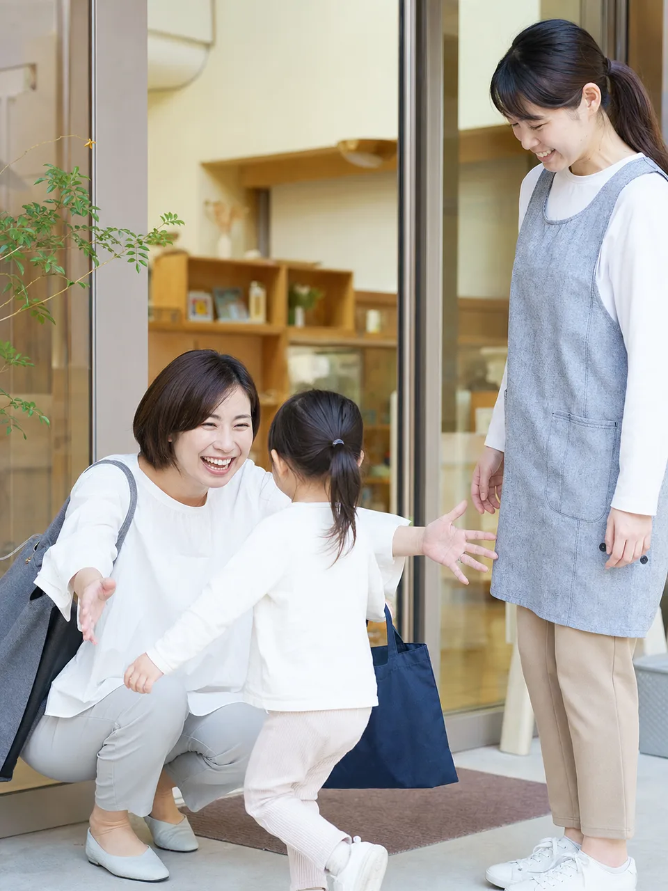 保育園へ迎えに行く日本人保護者（自然な縦位置写真）。保育園送迎、子育て、共働き、保育士の記事向け素材です。