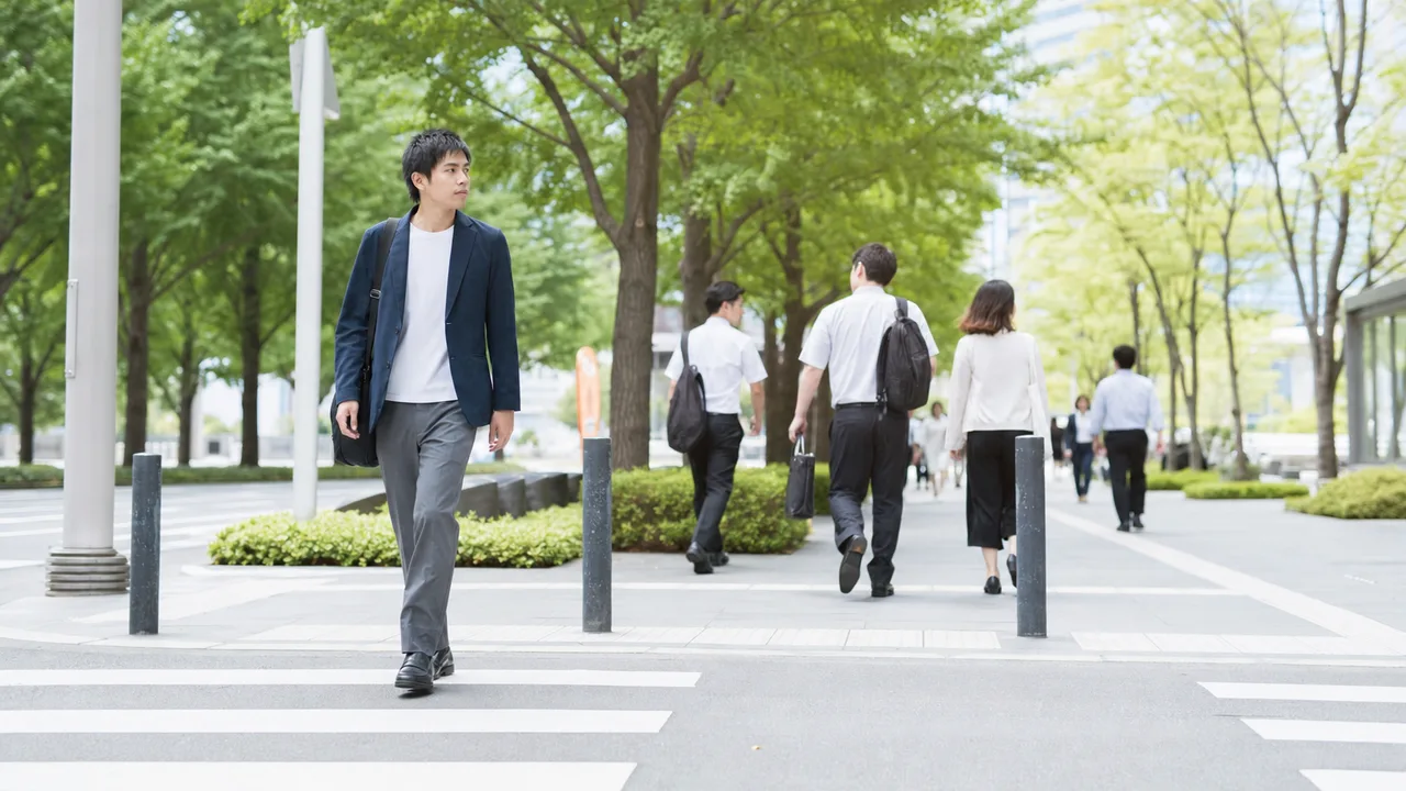徒歩で通勤する日本人会社員（横長・コピースペース）。徒歩通勤、通勤、会社員、歩くの記事や案内に使える商用素材です。