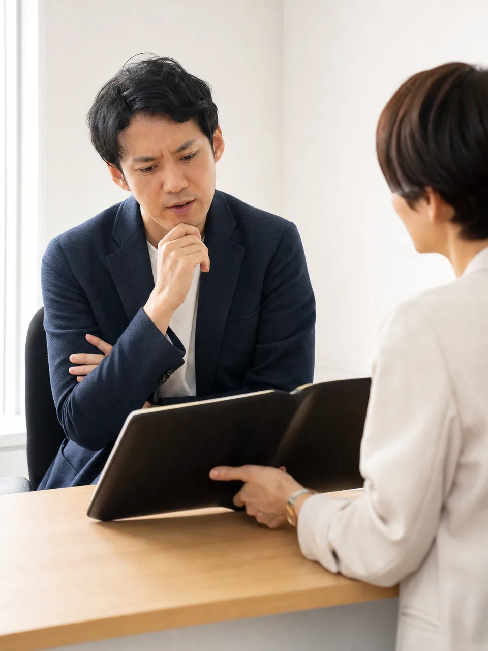 転職相談をする日本人会社員（自然な縦位置写真）。転職、人材紹介、キャリア形成の記事やサービス紹介に使える相談場面です。