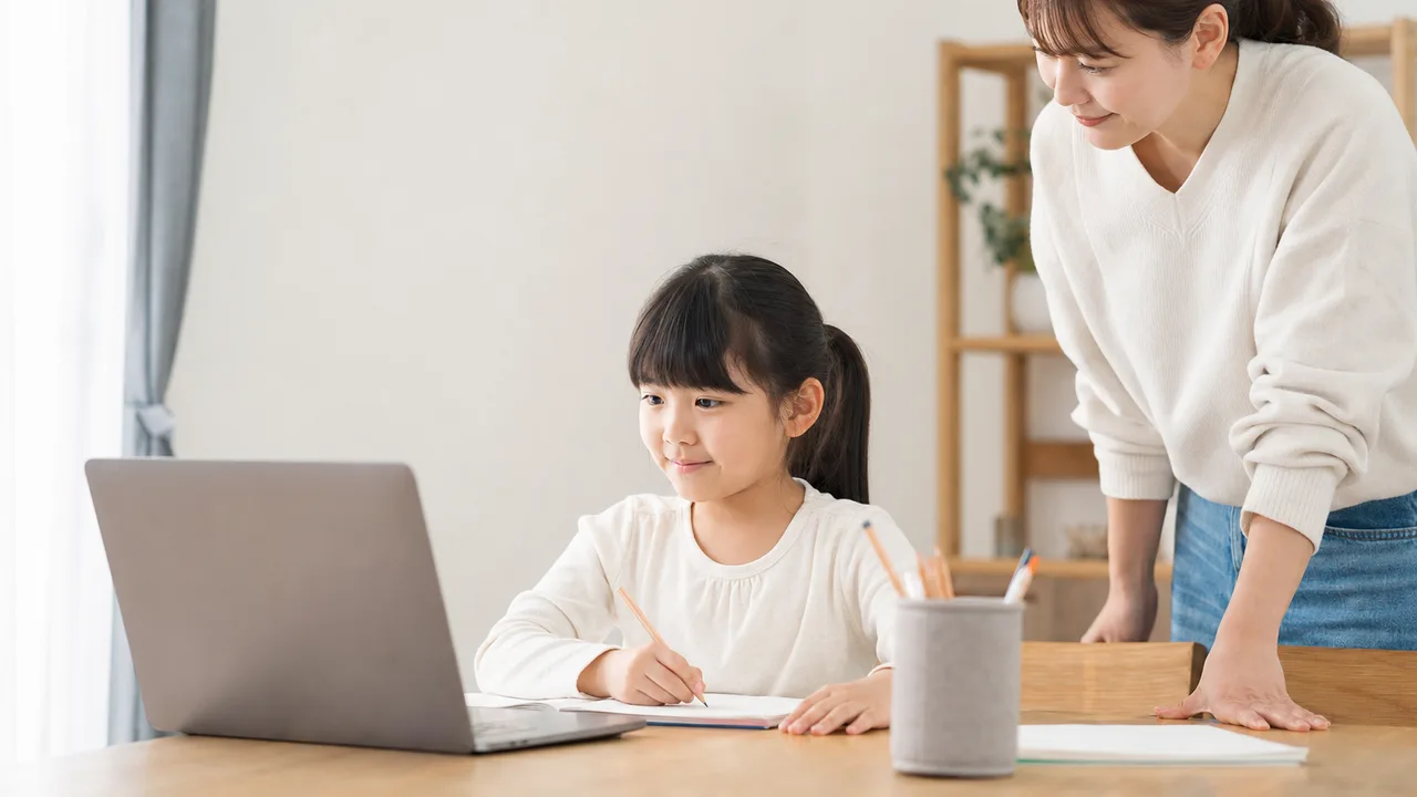 自宅でオンライン学習をする小学生（横長・コピースペース）。オンライン教育、家庭学習、学習支援サービスに使える親子素材です。