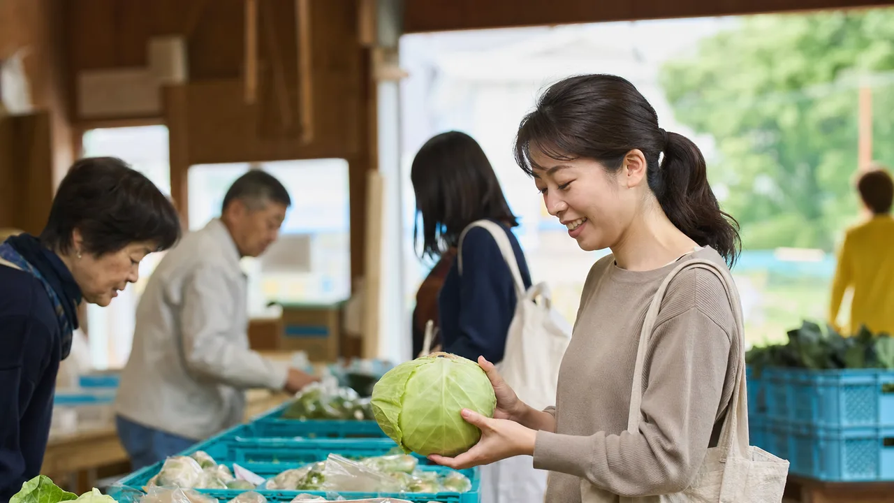 旬の野菜を選ぶ日本人（横長・コピースペース）。直売所、旬の野菜、農産物、地産地消の記事や案内に使える商用素材です。