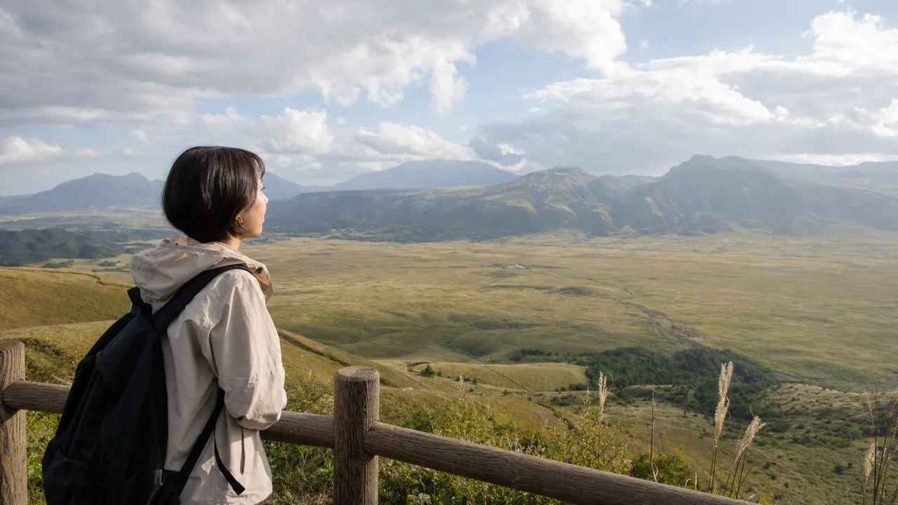 熊本の草原を旅する日本人（横長・コピースペース）。熊本、阿蘇、草原、九州旅行の記事向け素材です。