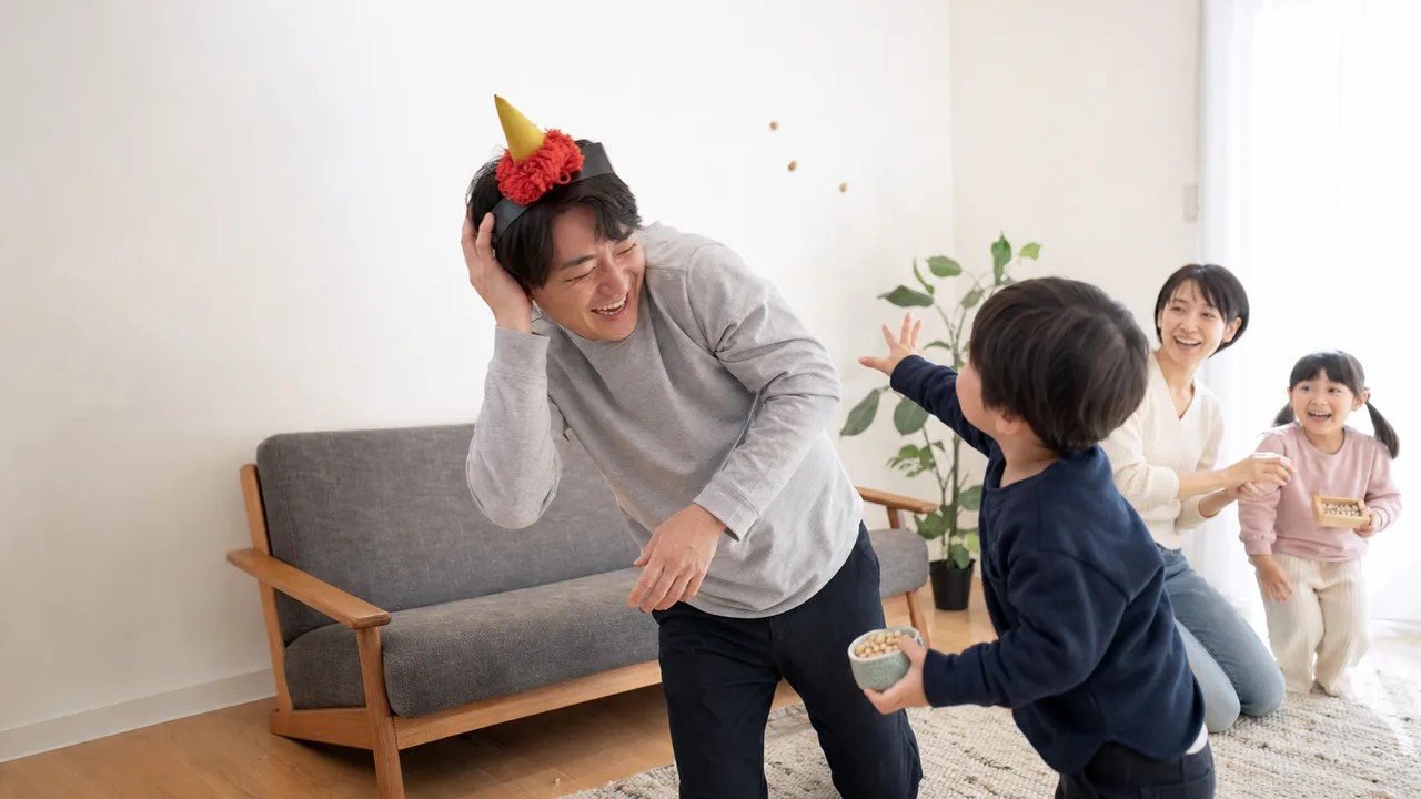 節分を楽しむ日本人家族（横長・コピースペース）。節分、豆まき、家族、日本の年中行事の記事向け素材です。