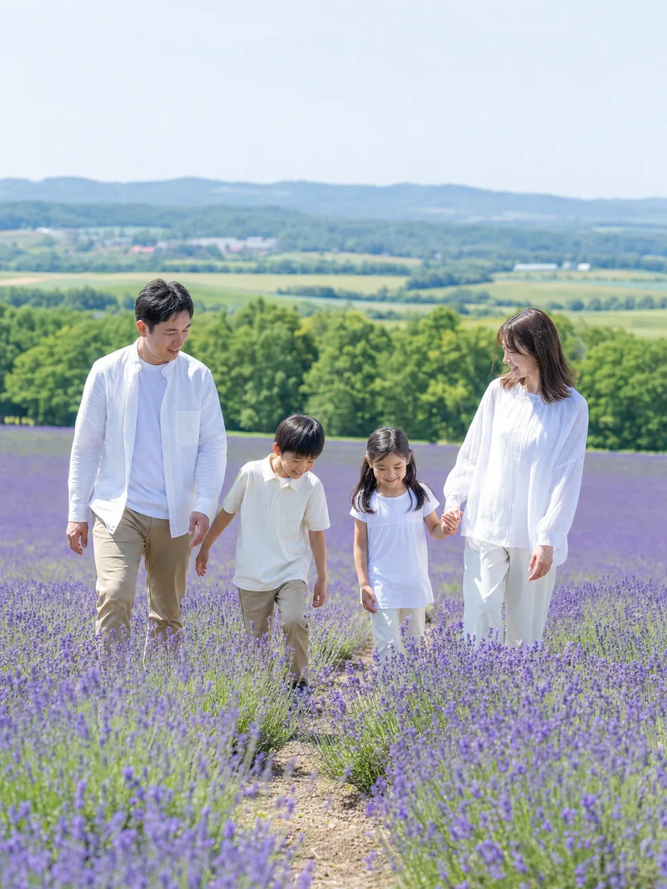 北海道の花畑を旅する日本人家族（自然な縦位置写真）。北海道、夏の国内旅行、家族観光、地域キャンペーン向け素材です。