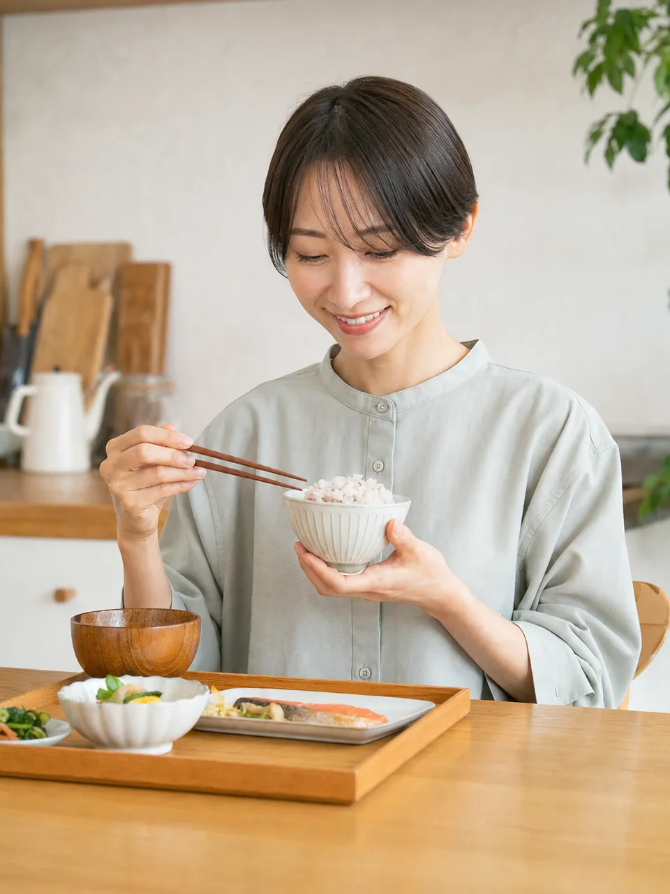 一人の食事を楽しむ日本人（自然な縦位置写真）。一人ごはん、一人暮らし、食事、ソロ活の記事や案内に使える商用素材です。