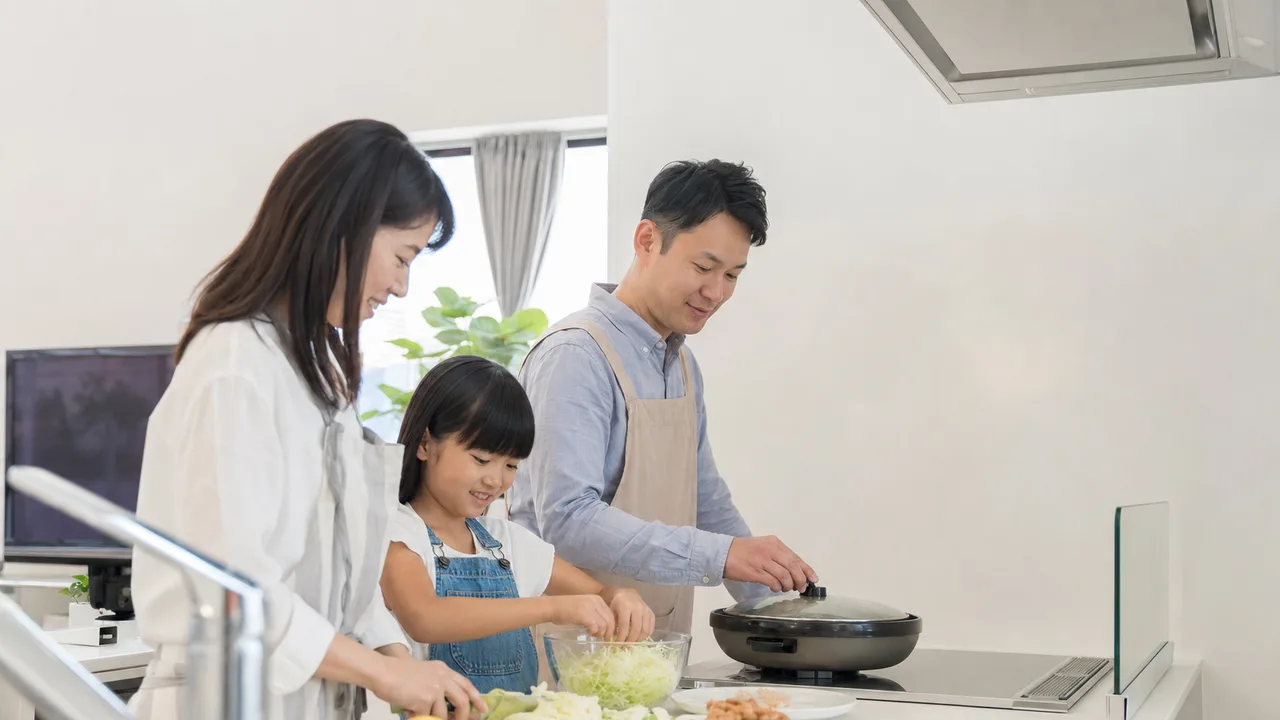 唐揚げを作る日本人家族（横長・コピースペース）。唐揚げ、家庭料理、親子料理、食卓の記事向け素材です。