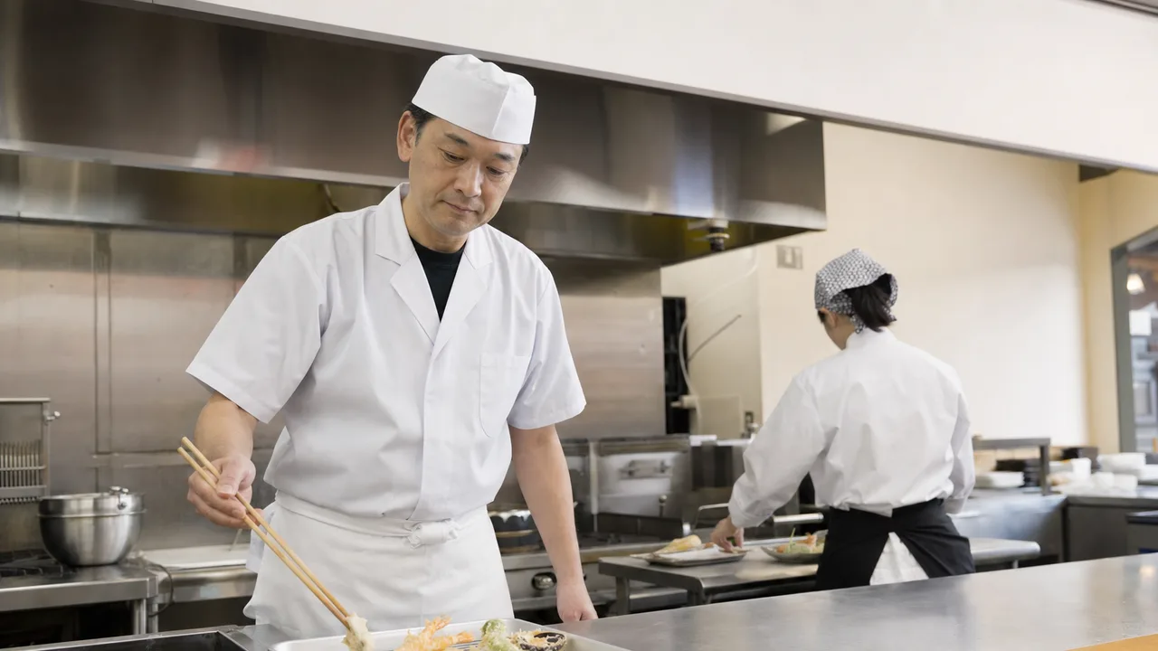 天ぷらを仕上げる日本人料理人（横長・コピースペース）。天ぷら、和食、料理人、飲食店の記事に使える食素材です。