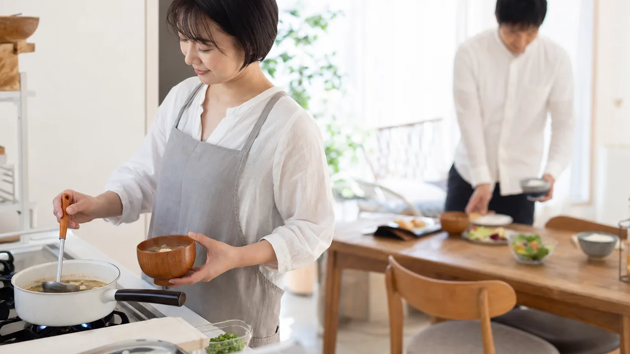 味噌汁を作る日本人の朝（横長・コピースペース）。味噌汁、和朝食、家庭料理、朝ごはんの記事向け素材です。