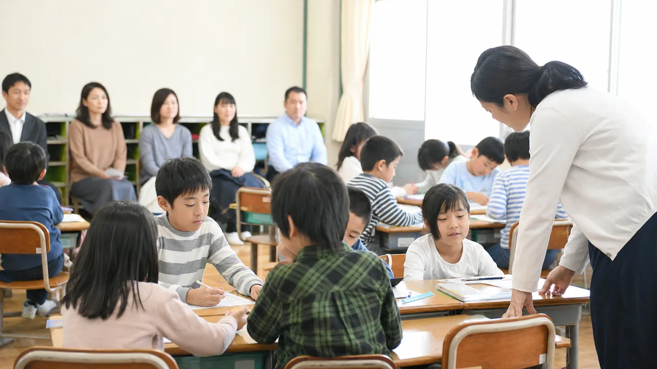 授業参観に参加する日本人保護者（横長・コピースペース）。授業参観、保護者、学校、子どもの学びの記事向け素材です。