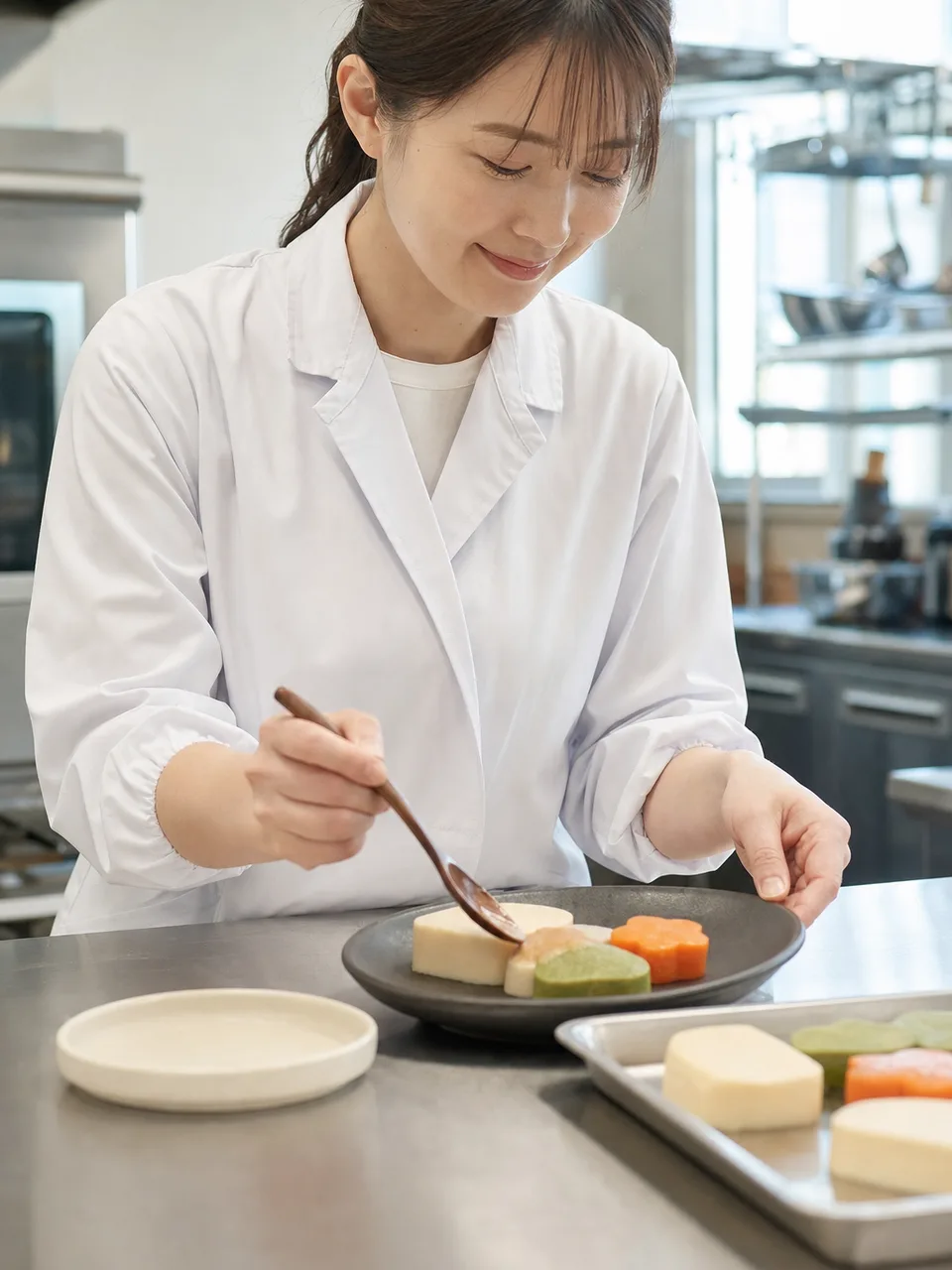 食べやすい食事を整える日本人専門職（自然な縦位置写真）。嚥下調整食、介護食、食べやすい食事、高齢者の記事や案内に使える商用素材です。