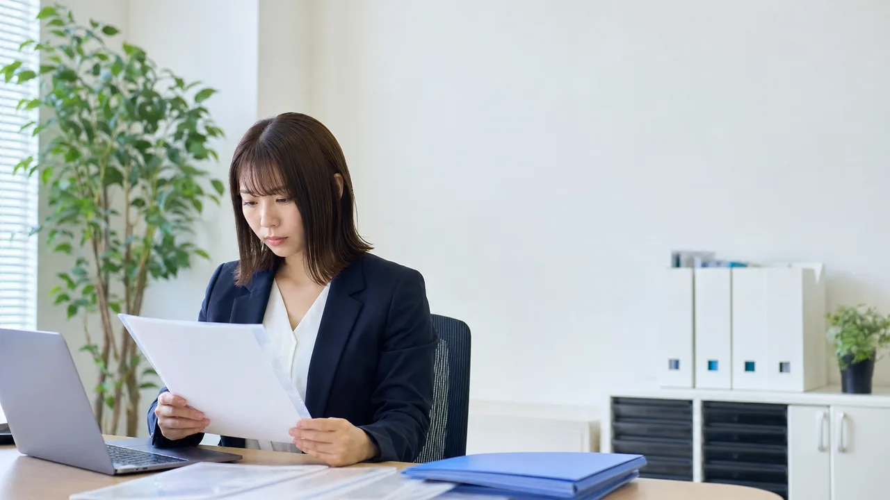 年末調整を確認する日本人人事担当者（横長・コピースペース）。年末調整の社内確認、人事の年末調整業務、年末調整、給与計算の記事や案内に使える商用素材です。