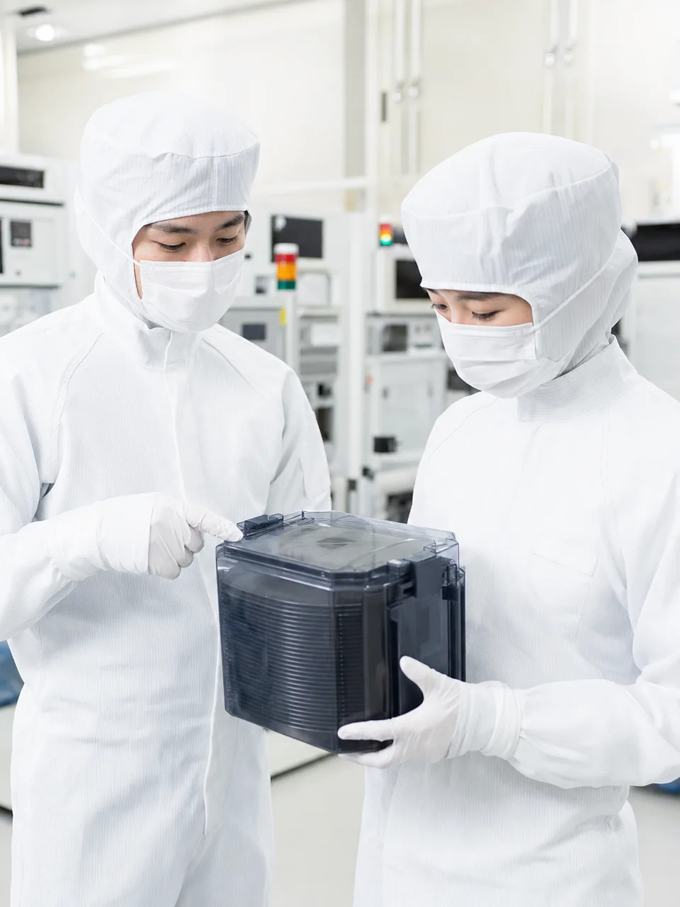 半導体工場で働く日本人技術者（自然な縦位置写真）。半導体工場、製造技術、クリーンルーム、産業の記事向け素材です。