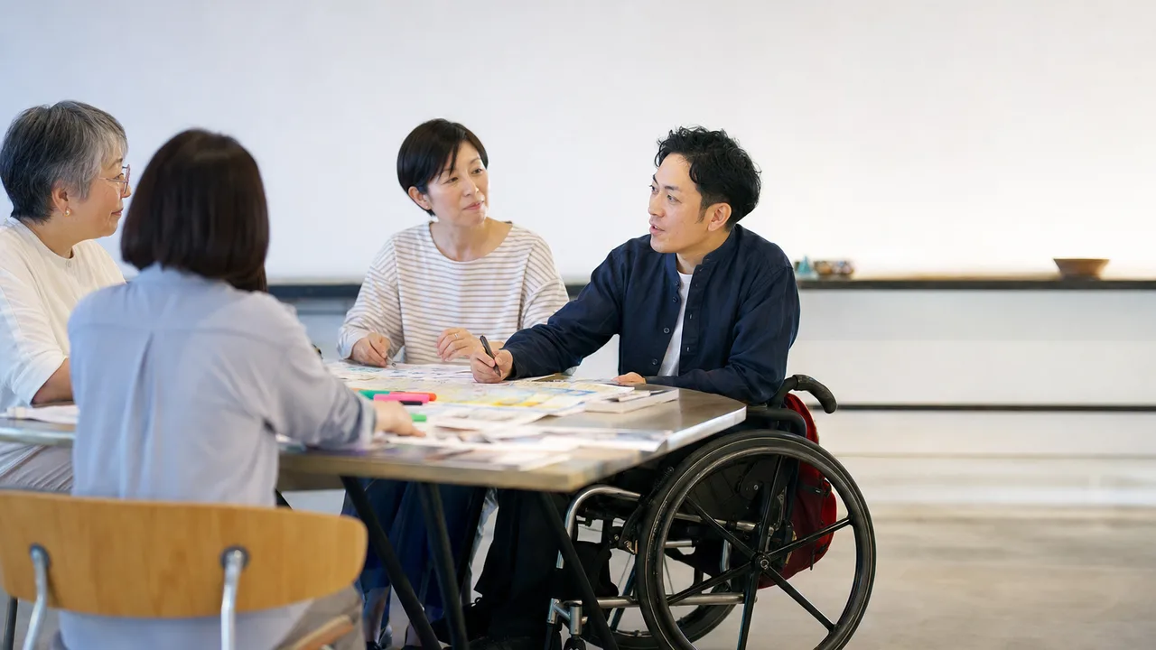 地域活動に参加する車椅子ユーザー（横長・コピースペース）。車椅子ユーザー、地域参加、アクセシビリティ、共生の記事向け素材です。