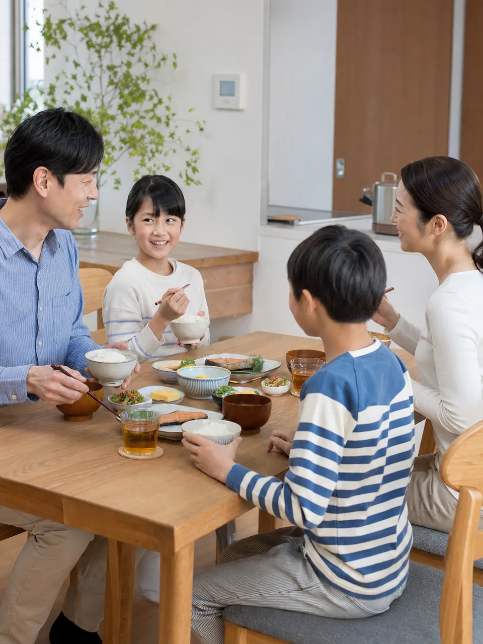 和朝食を囲む日本人家族（自然な縦位置写真）。和朝食、朝ごはん、家族、健康的な食事の記事向け素材です。