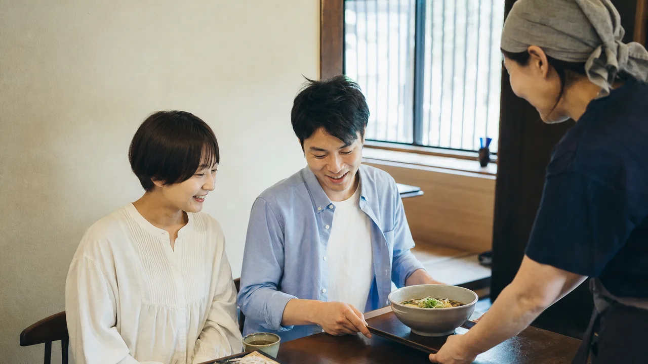 そばを味わう日本人（横長・コピースペース）。そば、蕎麦、和食、食文化の記事に使える素材です。