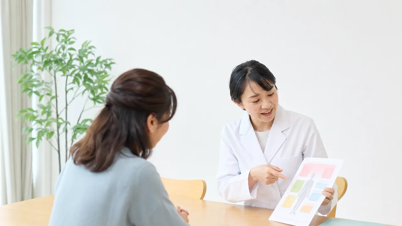 健康診断結果を説明する日本人医療者（横長・コピースペース）。健診結果説明、健康診断の結果、健康診断、予防医療の記事や案内に使える商用素材です。