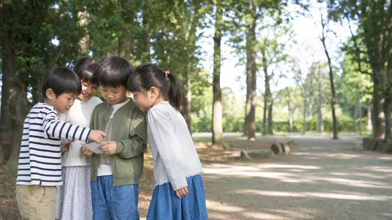 遊ぶ日本人小学生の友達（横長・コピースペース）。小学生の友達、友情、外遊び、子どもの記事向け素材です。