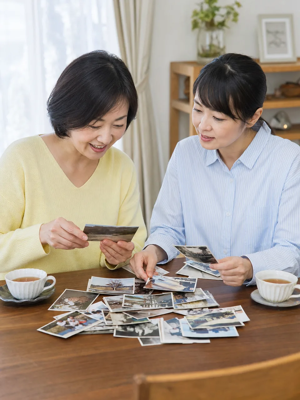 会話を楽しむ日本人の姉妹（自然な縦位置写真）。姉妹、きょうだい、会話、家族関係の記事向け素材です。