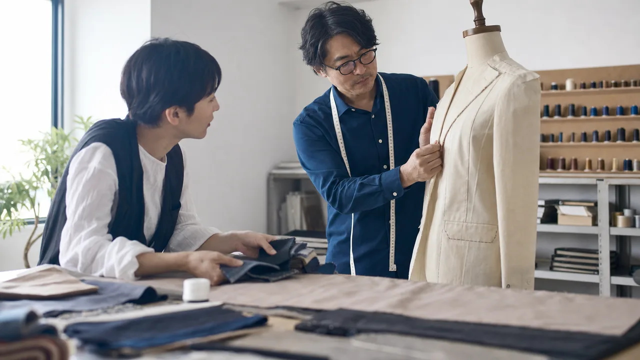 服を仕立てる日本人の洋裁職人（横長・コピースペース）。仕立て屋、洋裁、縫製、ものづくりの記事向け素材です。