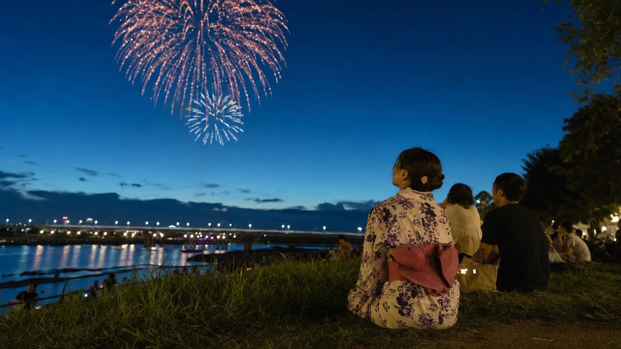 花火大会を楽しむ日本人の人々（横長・コピースペース）。花火大会、夏、地域イベント、観光の記事に使える季節素材です。