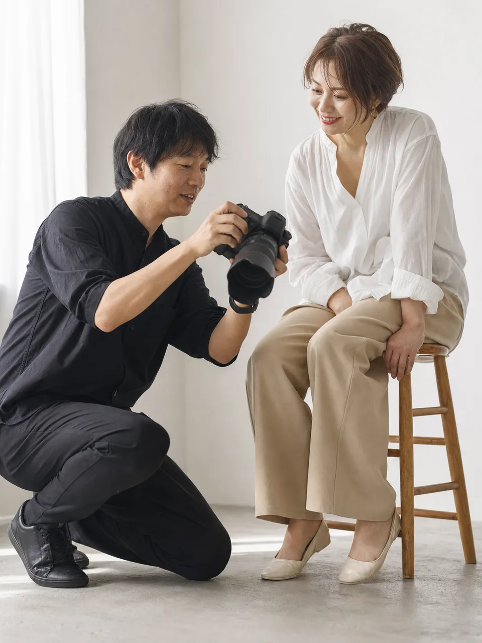 撮影する日本人写真家（自然な縦位置写真）。写真家、カメラマン、撮影、クリエイティブ職の記事向け素材です。