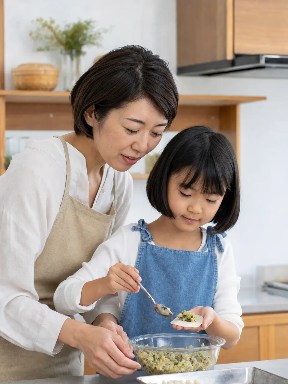 餃子を包む日本人家族（自然な縦位置写真）。餃子、家庭料理、親子、食育の記事に使える素材です。