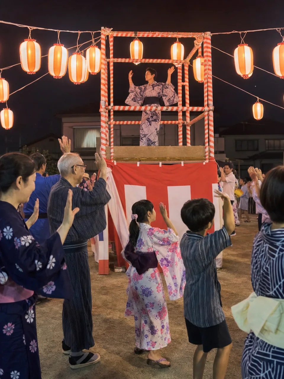 盆踊りを楽しむ日本人地域住民（自然な縦位置写真）。地域の盆踊り、盆踊り練習、夏祭り、地域行事の記事や案内に使える商用素材です。