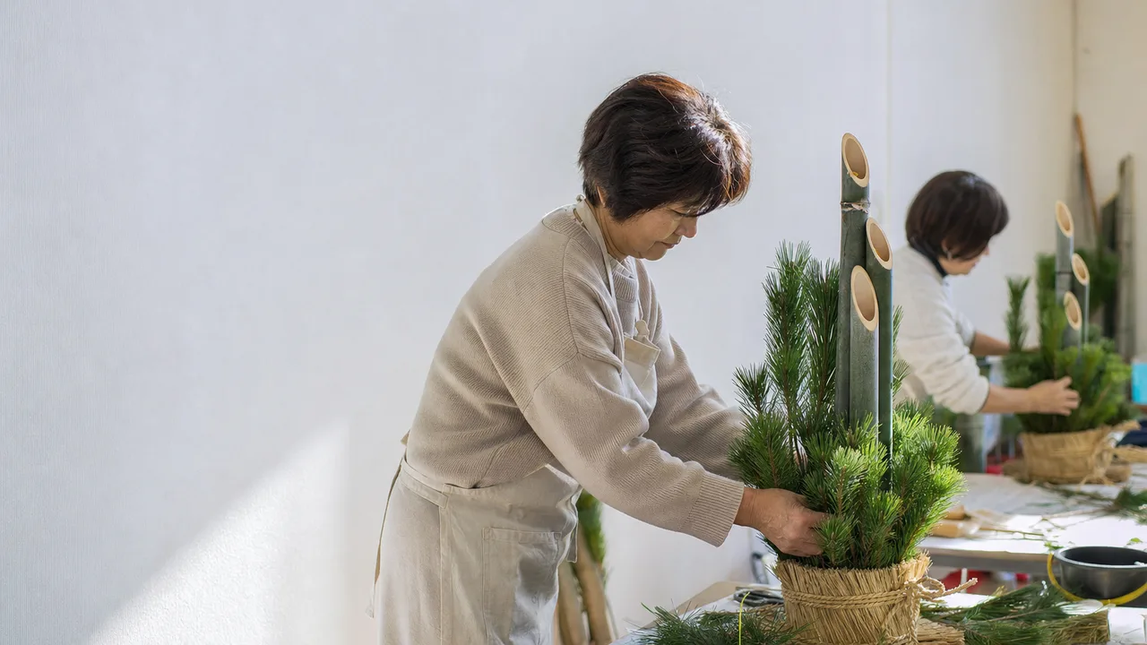 門松を作る日本人地域住民（横長・コピースペース）。門松作り、正月飾り、新年準備、伝統文化の記事や案内に使える商用素材です。