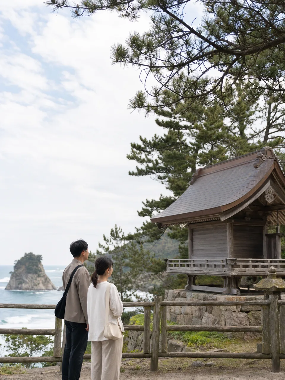島根の海辺の文化景観を巡る旅行者（自然な縦位置写真）。島根旅行、海辺の神社、山陰旅行、文化景観の記事や案内に使える商用素材です。
