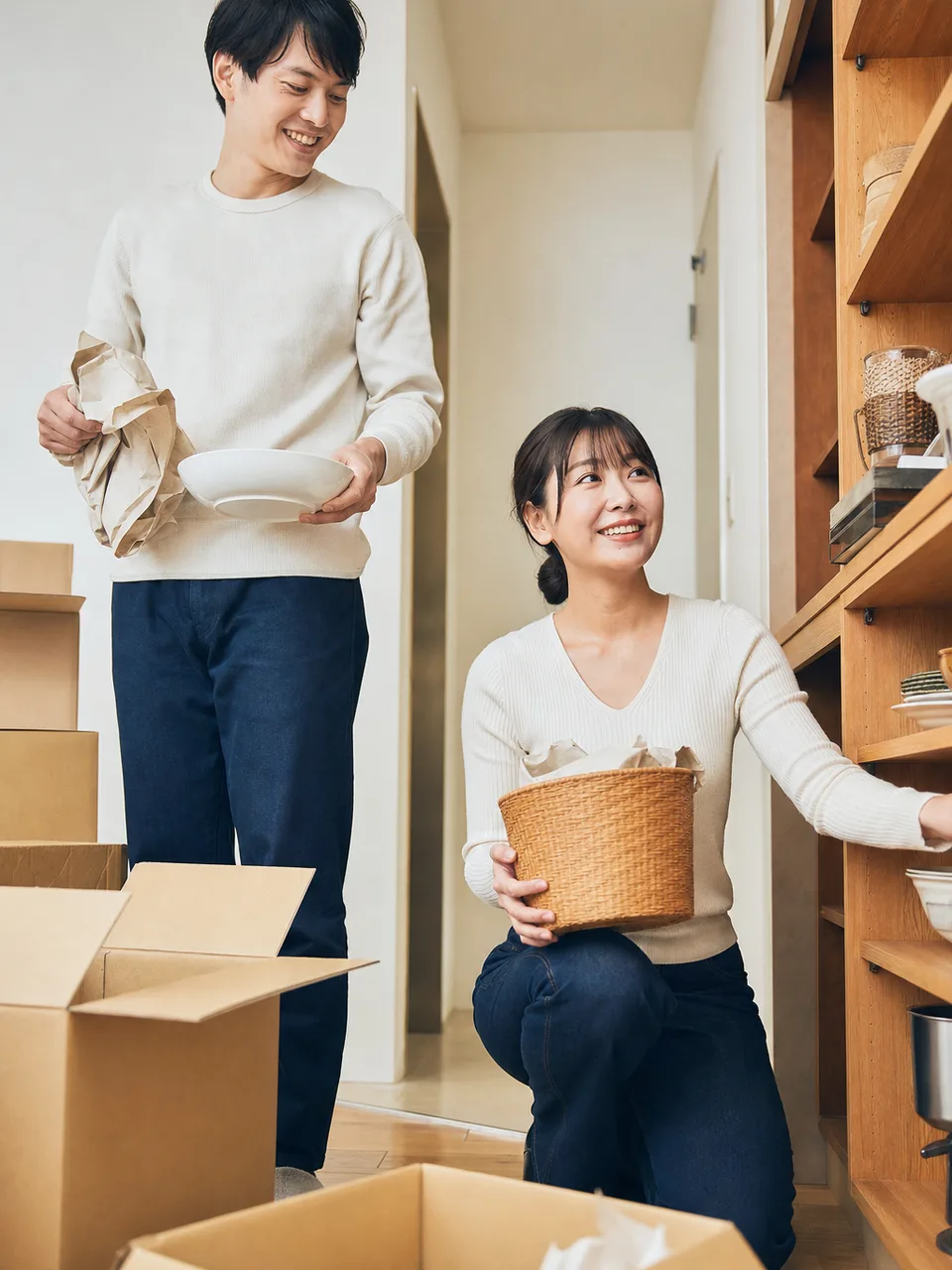新生活を整える日本人の新婚夫婦（自然な縦位置写真）。新婚夫婦、新生活、二人暮らし、協力の記事向け素材です。