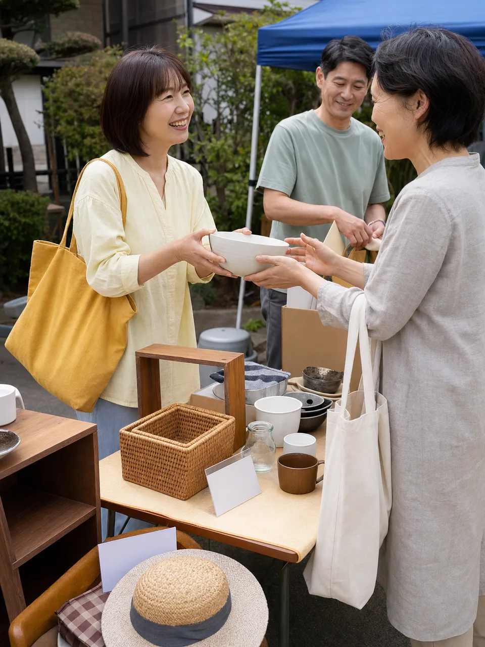 地域のフリーマーケットを楽しむ日本人（自然な縦位置写真）。フリーマーケット、リユース、地域イベント、中古品の記事や案内に使える商用素材です。