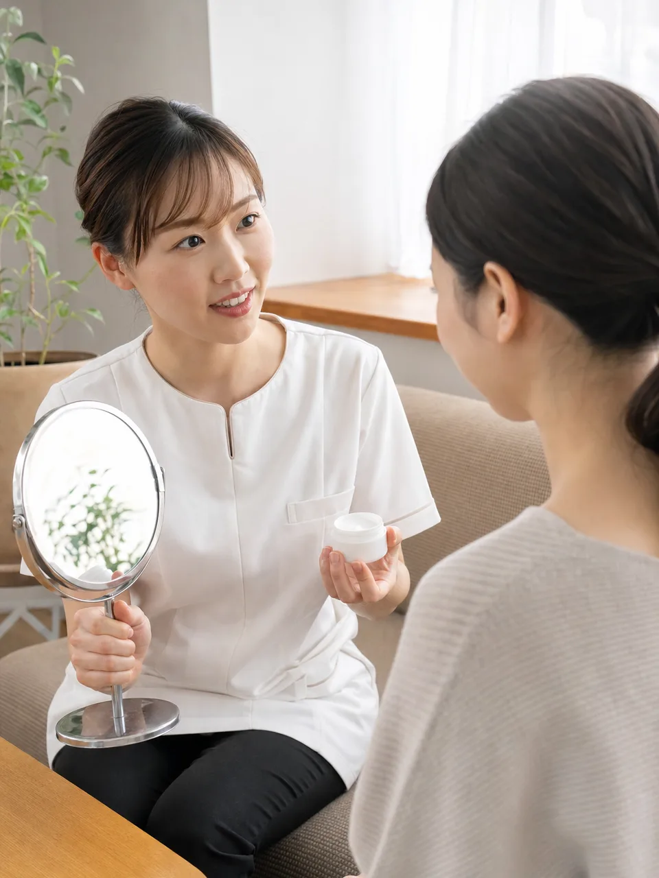 肌の相談を受ける日本人エステティシャン（自然な縦位置写真）。エステティシャン、エステサロン、美容相談の記事向け素材です。
