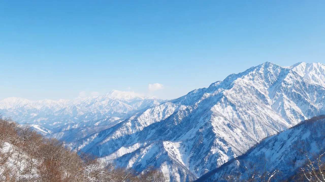 冬の日本の雪山（横長・余白背景）。雪山、冬山、雪景色、自然風景向け素材です。