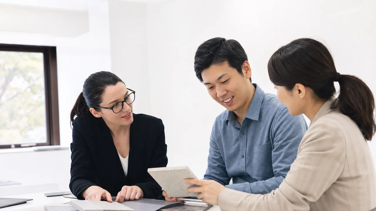 多言語で協働する日本人と海外顧客（横長・コピースペース）。多言語会議、海外顧客、国際ビジネス、通訳の記事や案内に使える商用素材です。
