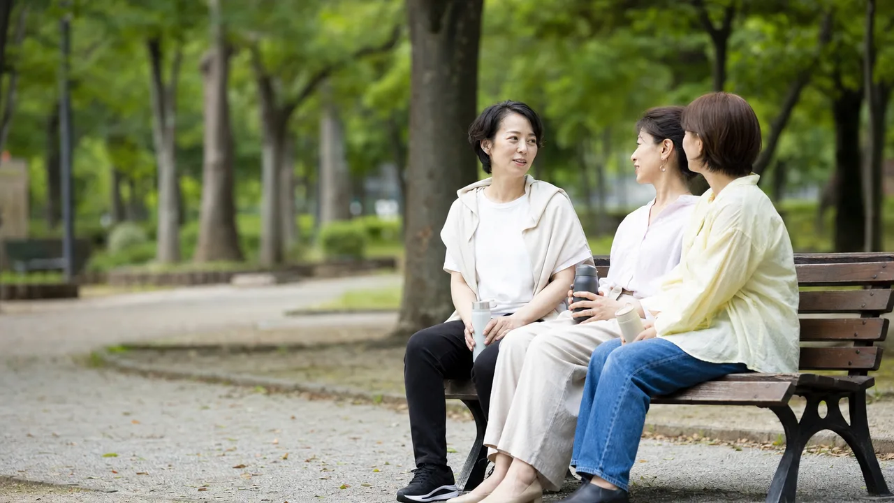 会話を楽しむ日本人の女友達（横長・コピースペース）。女友達、友情、会話、休日の記事向け素材です。