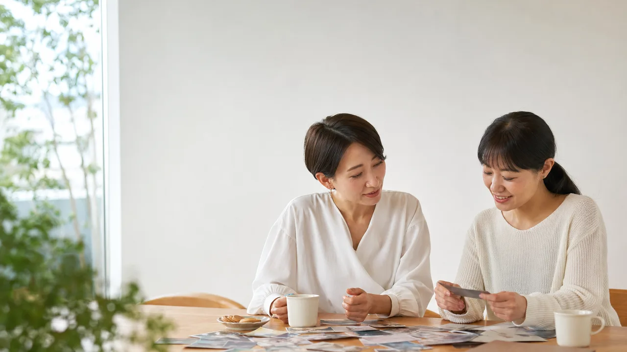 会話を楽しむ日本人の姉妹（横長・コピースペース）。姉妹、きょうだい、会話、家族関係の記事向け素材です。