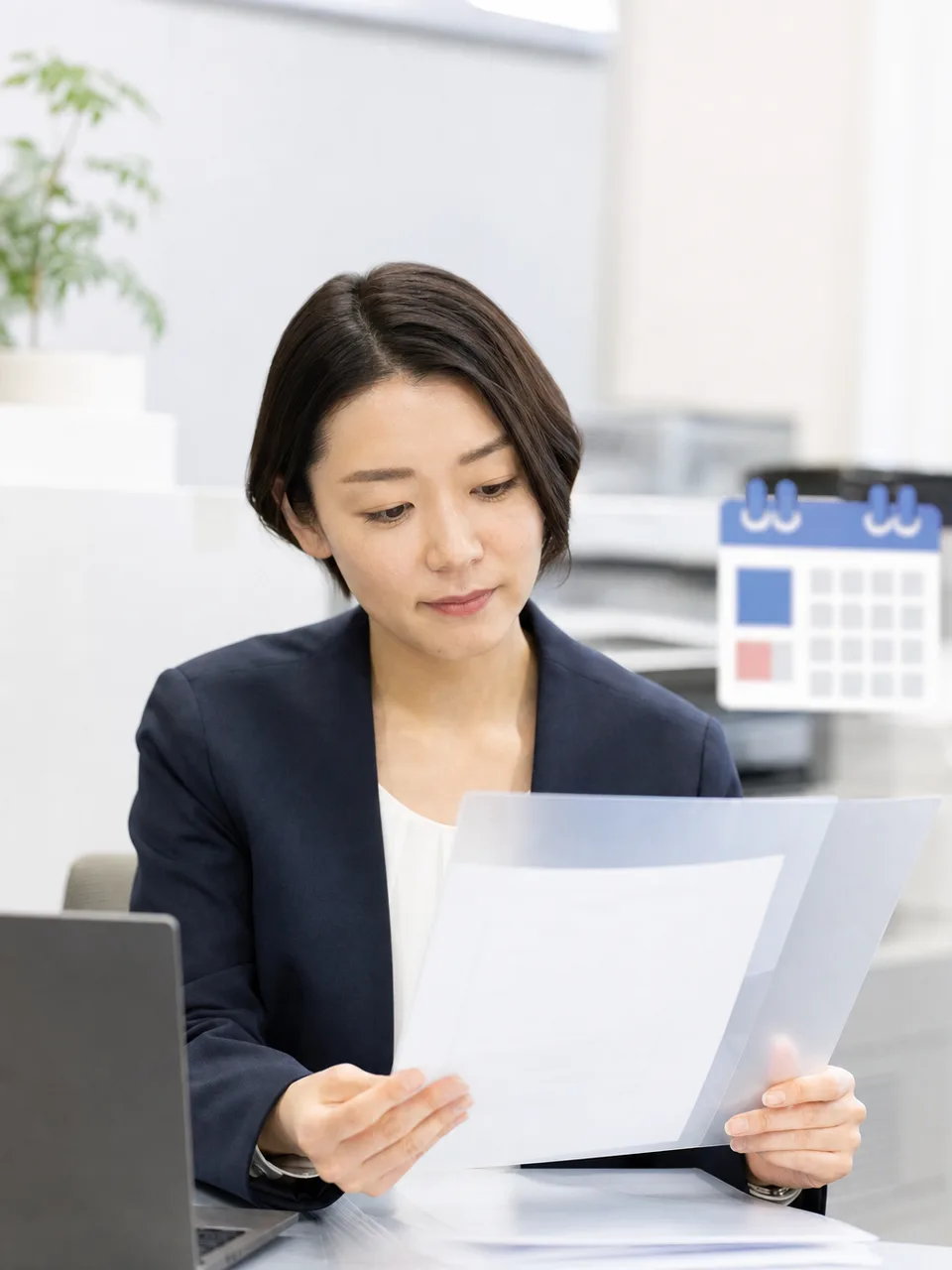 年末調整を確認する日本人人事担当者（自然な縦位置写真）。年末調整の社内確認、人事の年末調整業務、年末調整、給与計算の記事や案内に使える商用素材です。