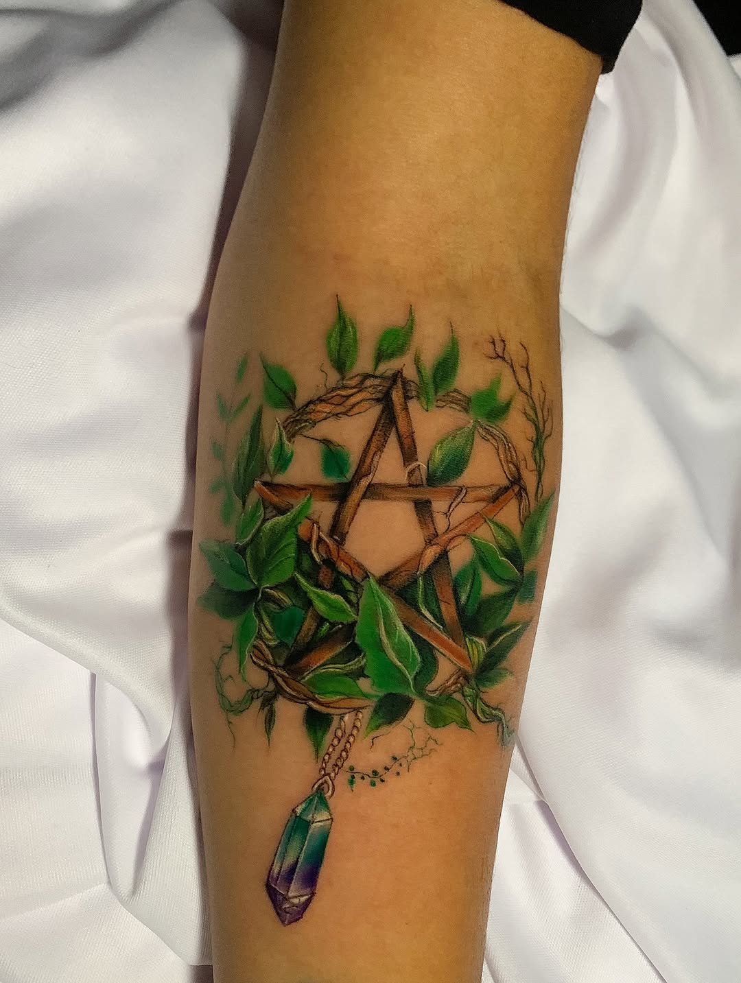 ✨ Símbolos não precisam estar apenas nos livros ou nos rituais… eles podem viver na sua pele.
Esse pentagrama entrelaçado em galhos, folhas e cristal 