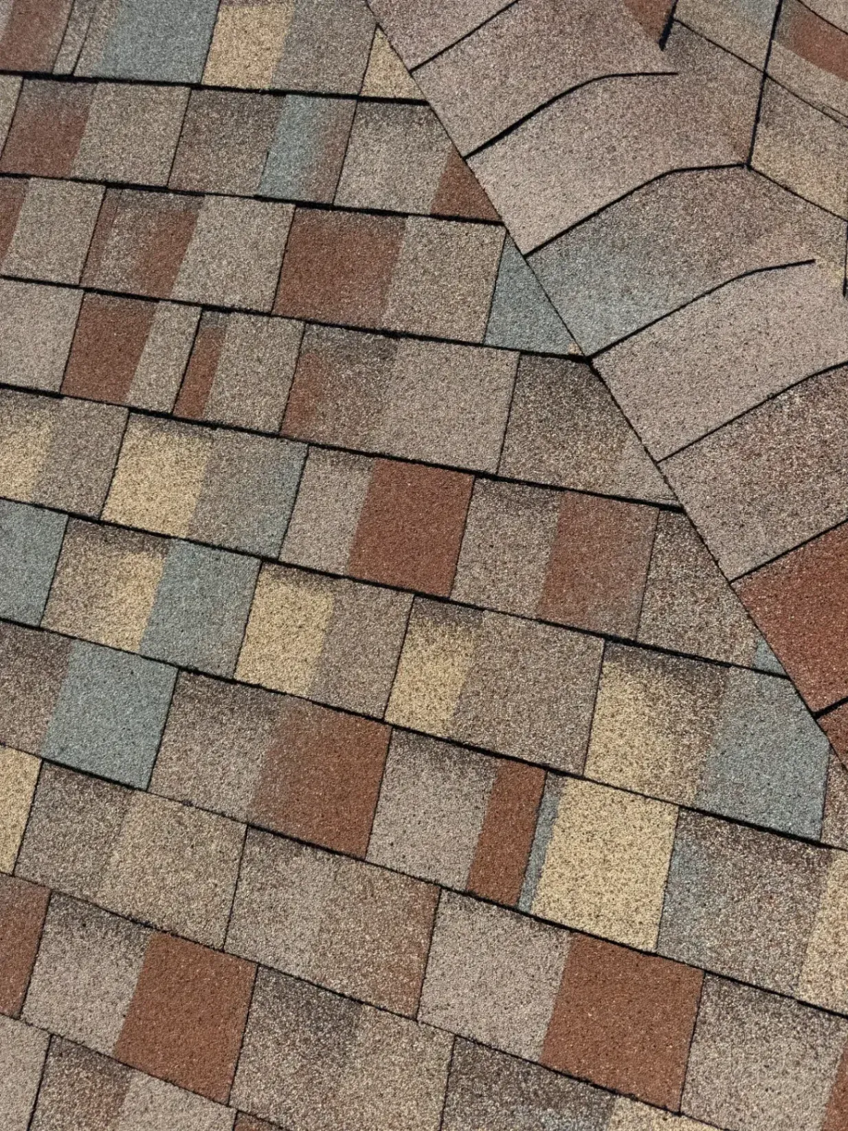 Close-up of installed multi-toned brown, tan, and gray asphalt roof shingles. Claim Your 5-to-20 Year Transparent Warranty in Your Roof Installation