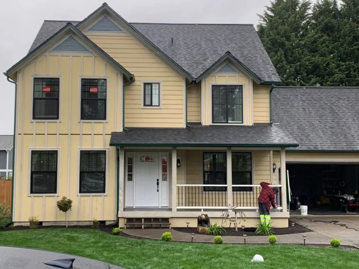 Professional house painters applying premium weather-resistant paint during an exterior painting project in Bellevue, WA, to protect against moisture.