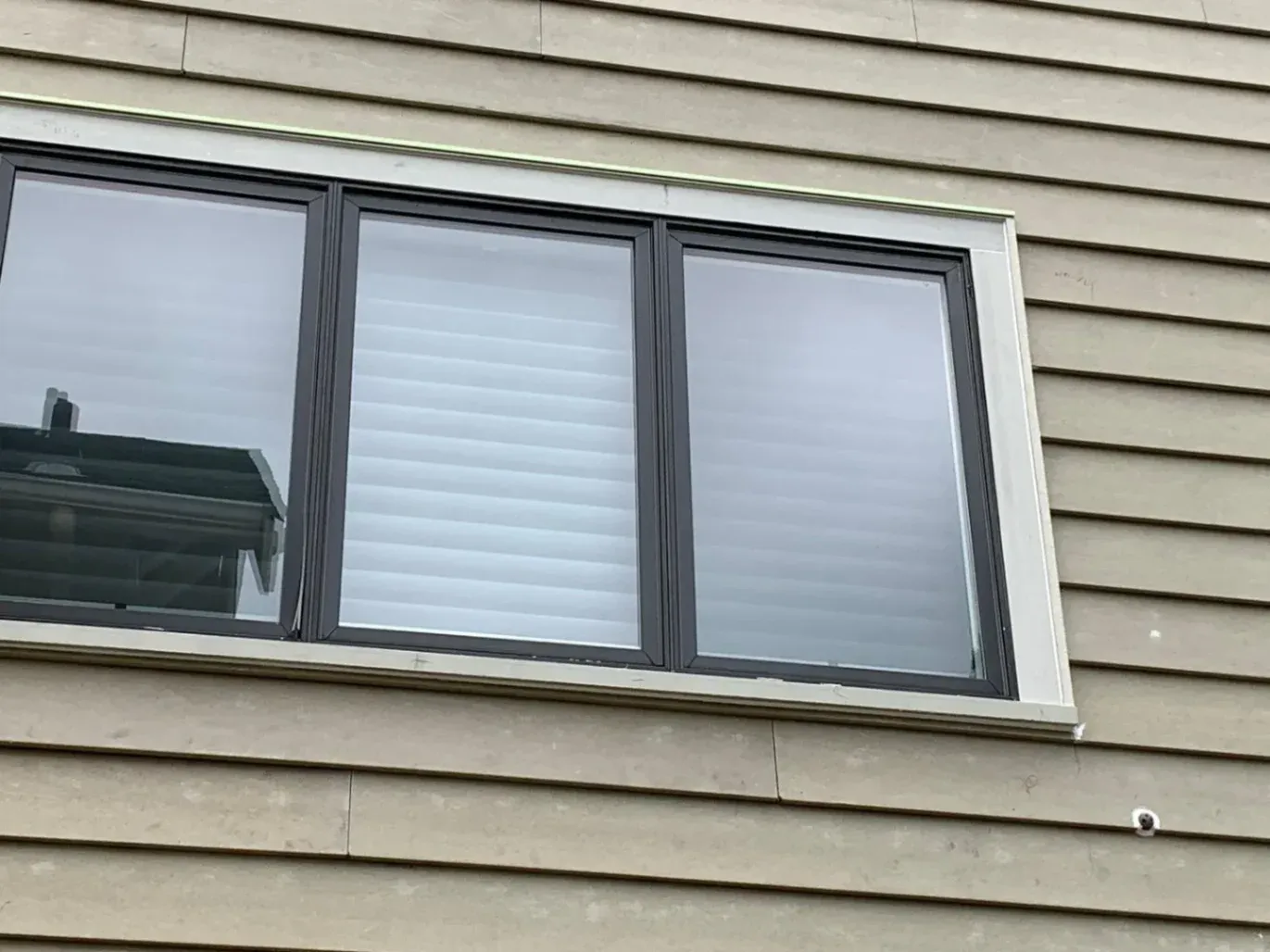 A professional contractor from MES Exteriors Inc inspecting an exterior wall for hidden wood rot, demonstrating their 'House Doctor' repair process in Redmond, WA.