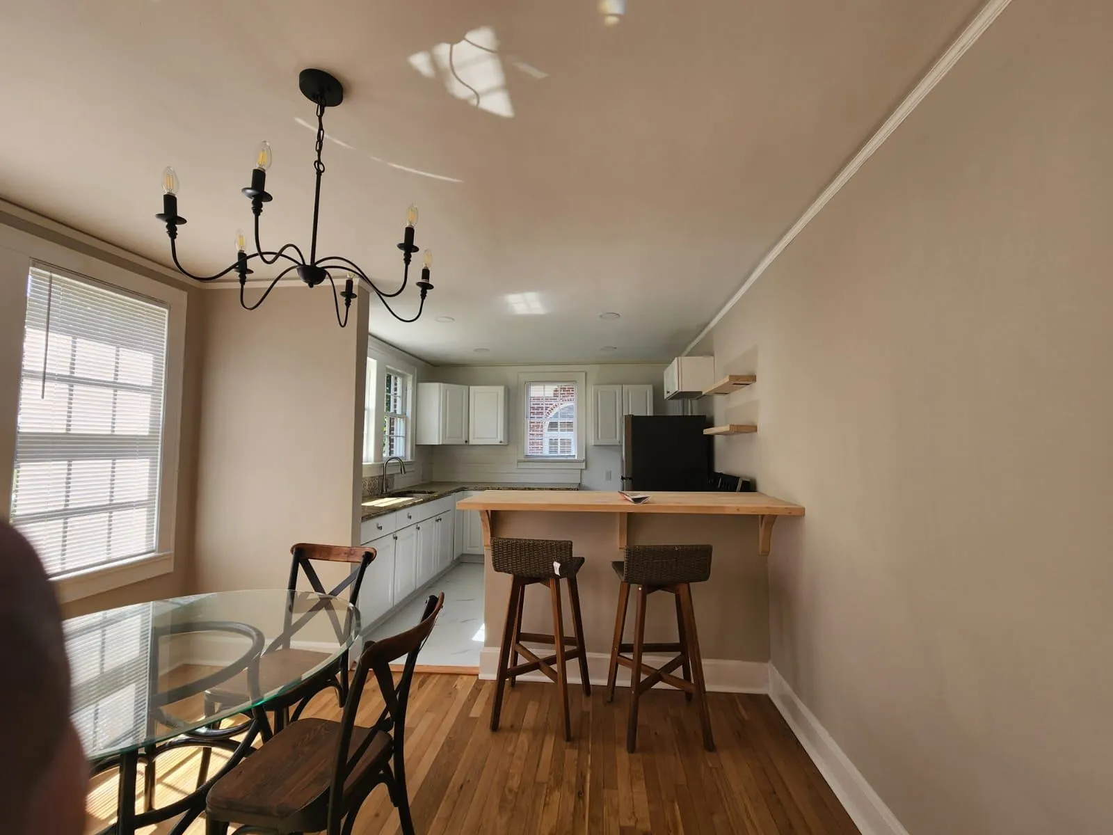 Kitchen and dining area with freshly painted beige walls and white trim.