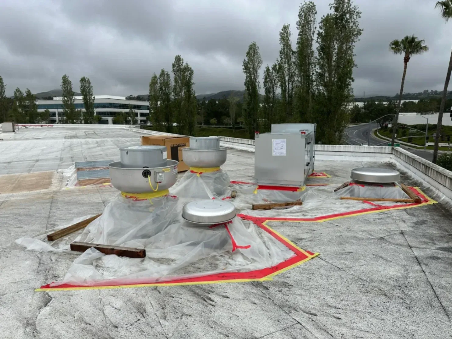 Rooftop commercial HVAC equipment staged for installation in Santa Ana, CA, under cloudy skies.