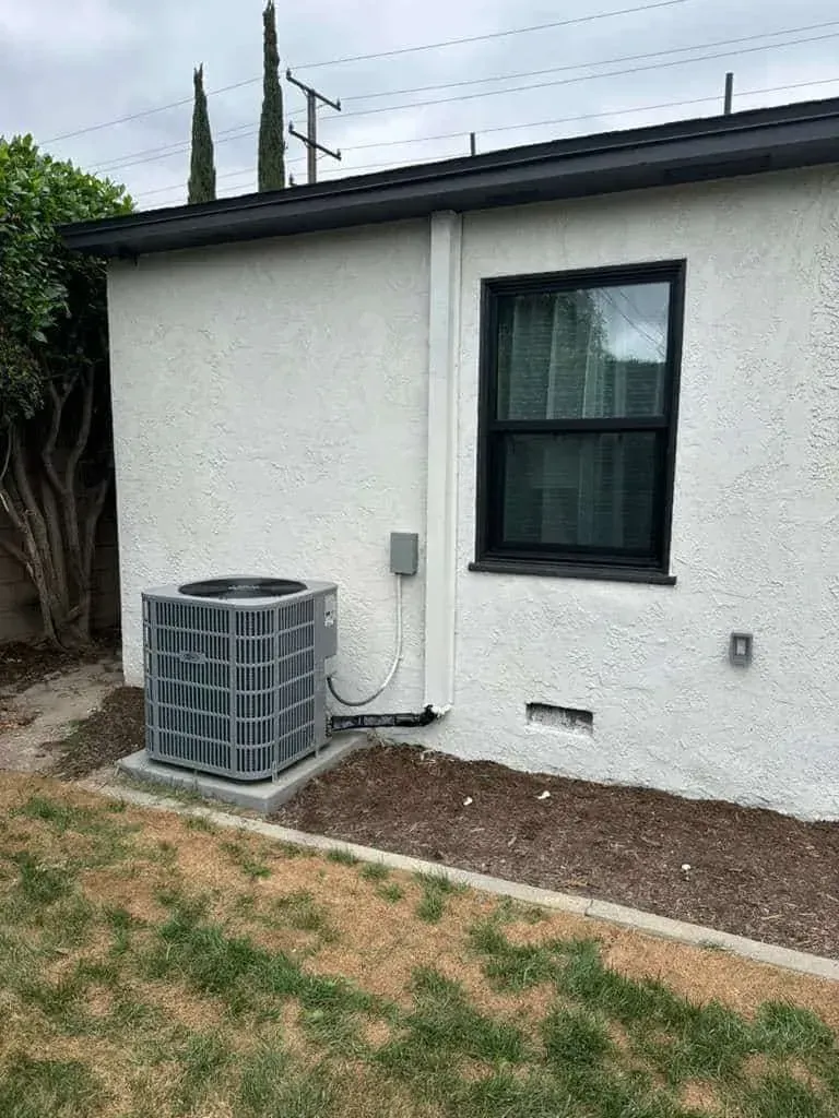 Newly installed outdoor air conditioner beside a white house in Santa Ana. AAC Heating and Air